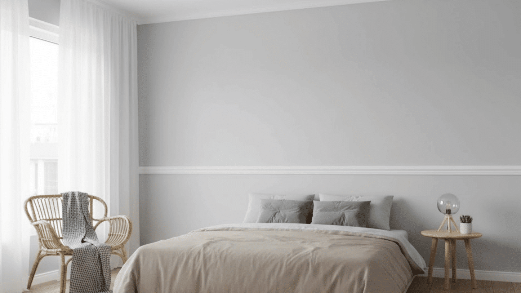 calm bedroom with a classic white wooden chair rail dividing soft gray walls