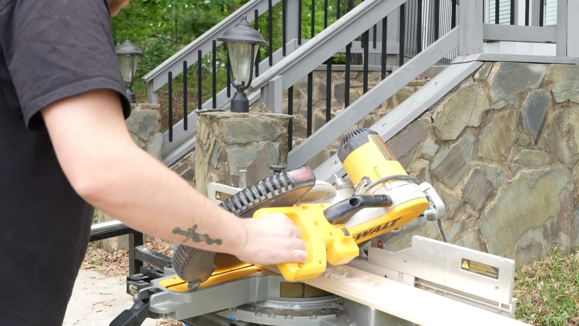 worker cutting chair rail molding with a power miter saw outdoors