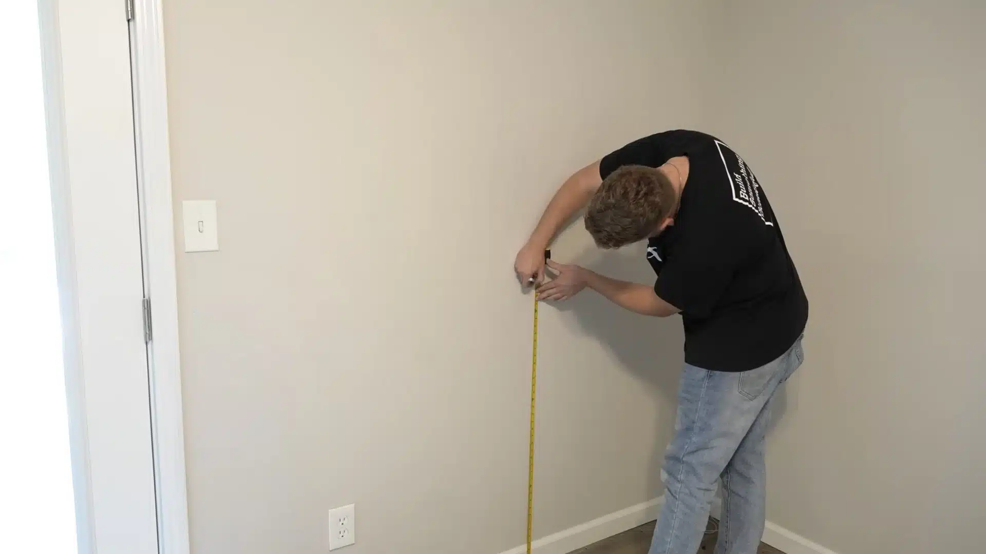 installer measuring and marking the correct chair rail height on an interior wall