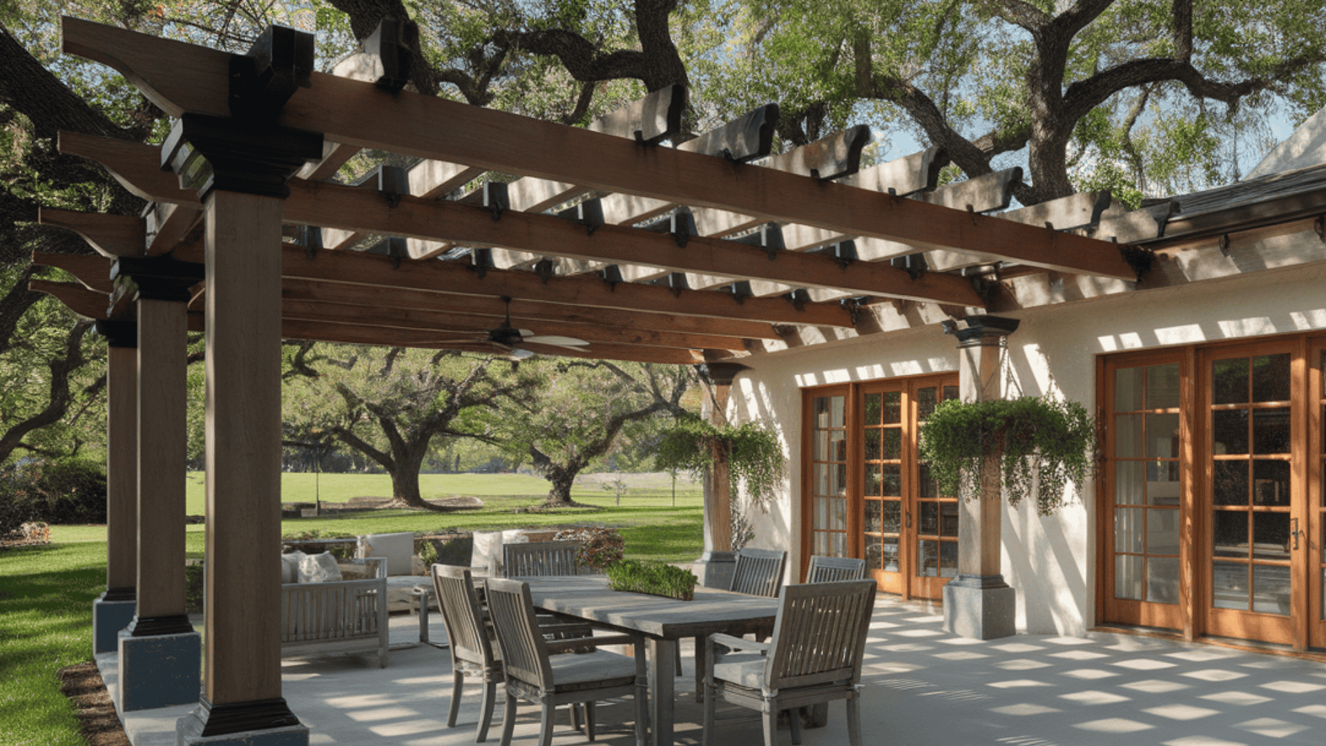 traditional open-slat pergola with timber beams shades an outdoor dining patio beside the home.