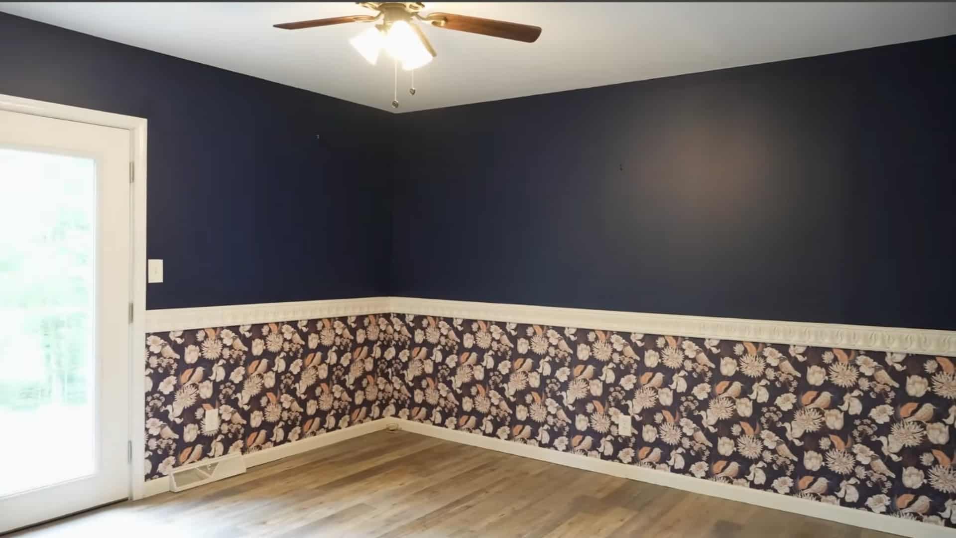 finished room with a dark upper wall and floral chair rail border around the lower wall
