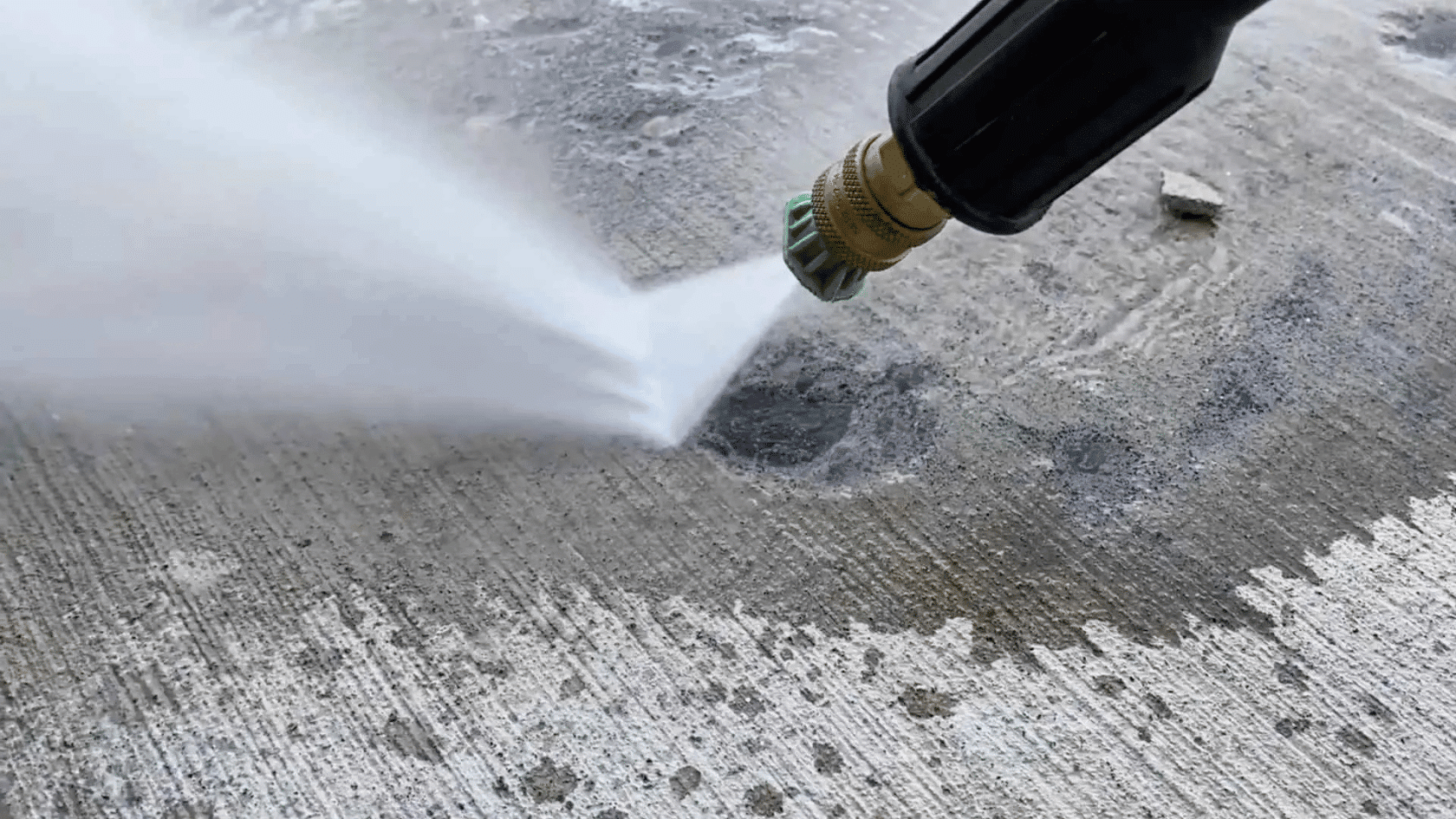 pressure washing a concrete crack to remove dirt and dust before applying concrete crack filler.
