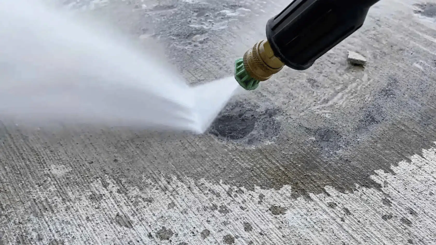 pressure washing a concrete crack to remove dirt and dust before applying concrete crack filler.