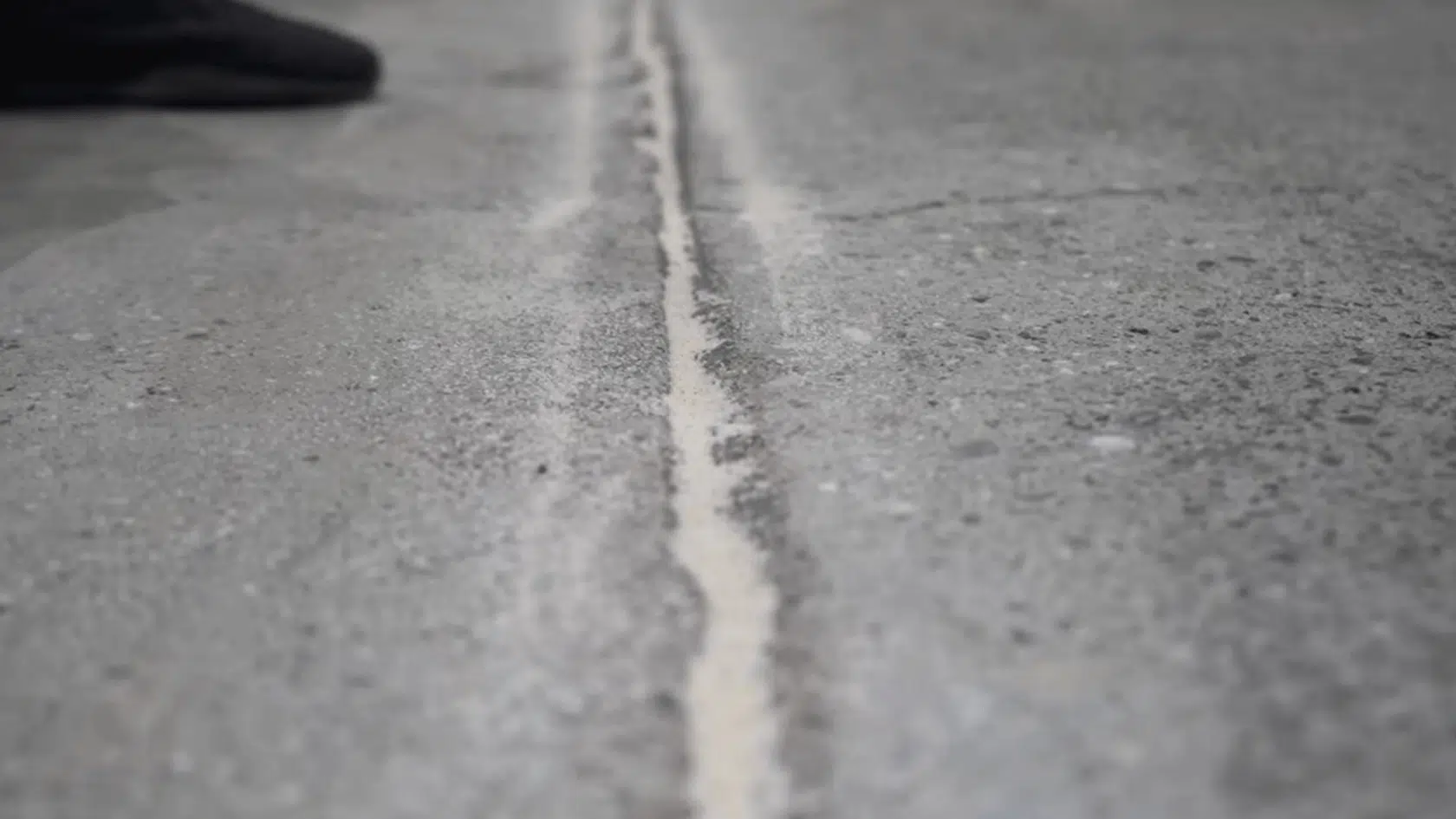 silica sand packed into a deep concrete crack before applying concrete crack repair filler.