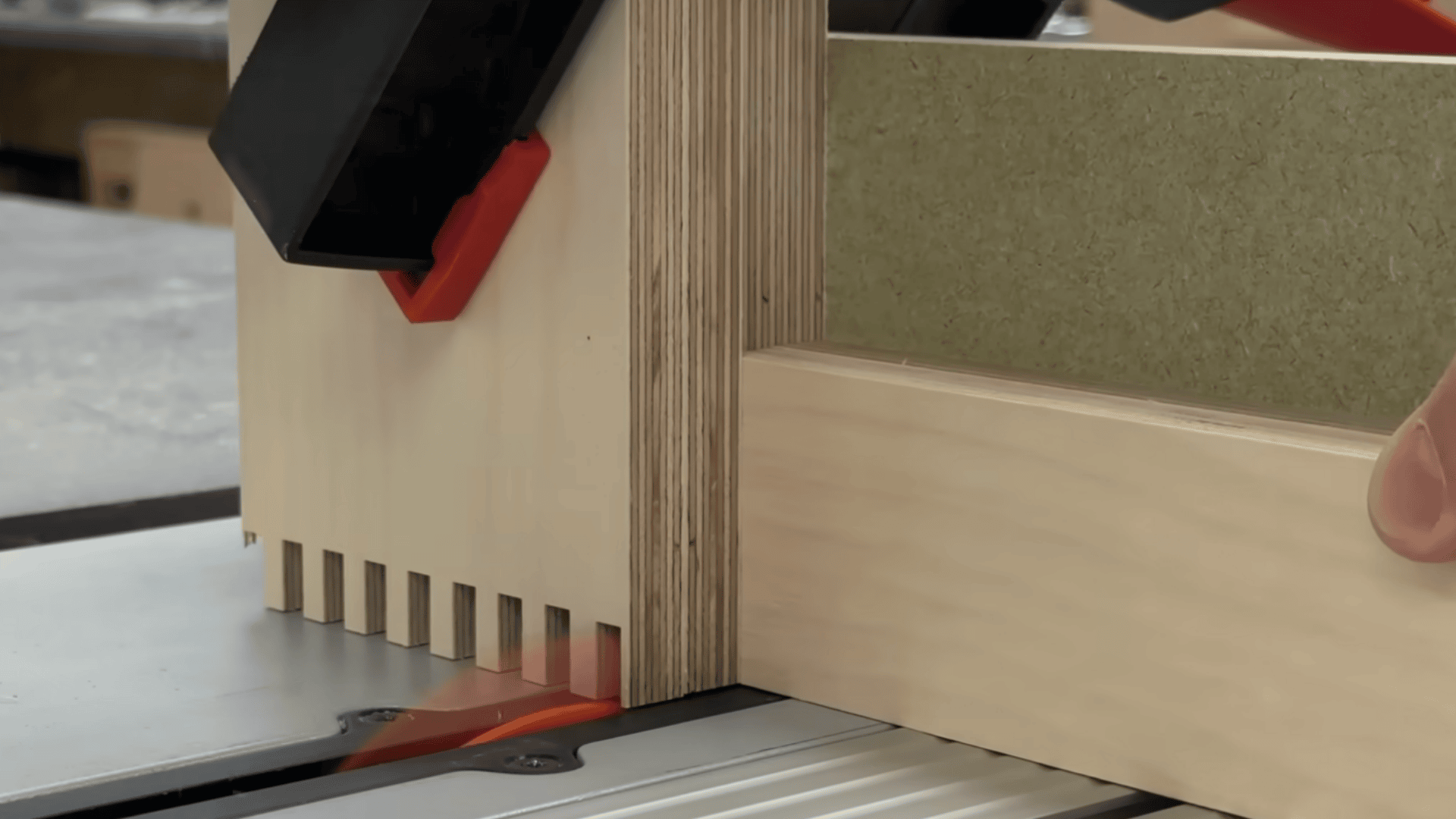 wood panels clamped together for batch cutting accurate box joint fingers on a table saw.