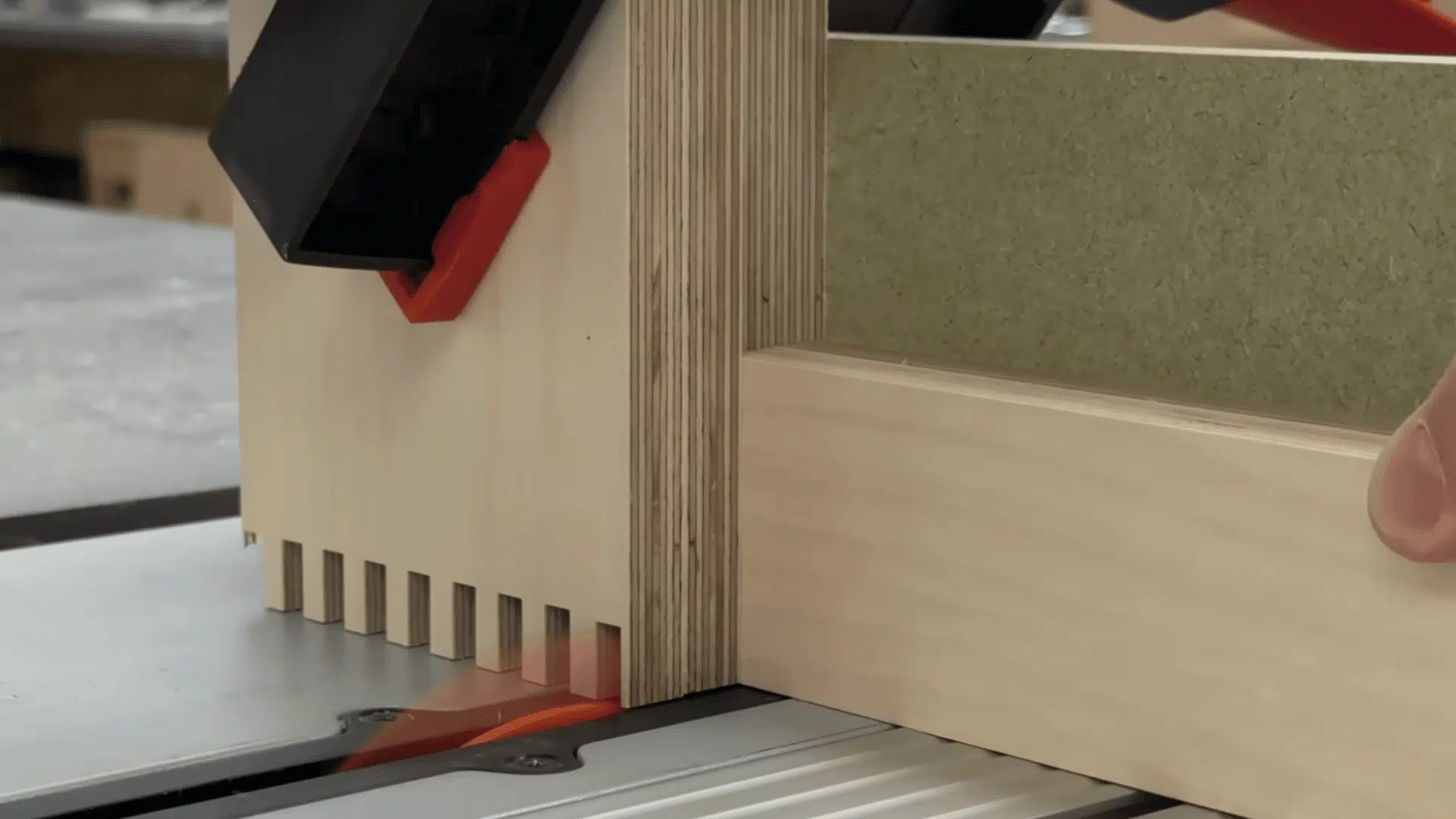 wood panels clamped together for batch cutting accurate box joint fingers on a table saw.